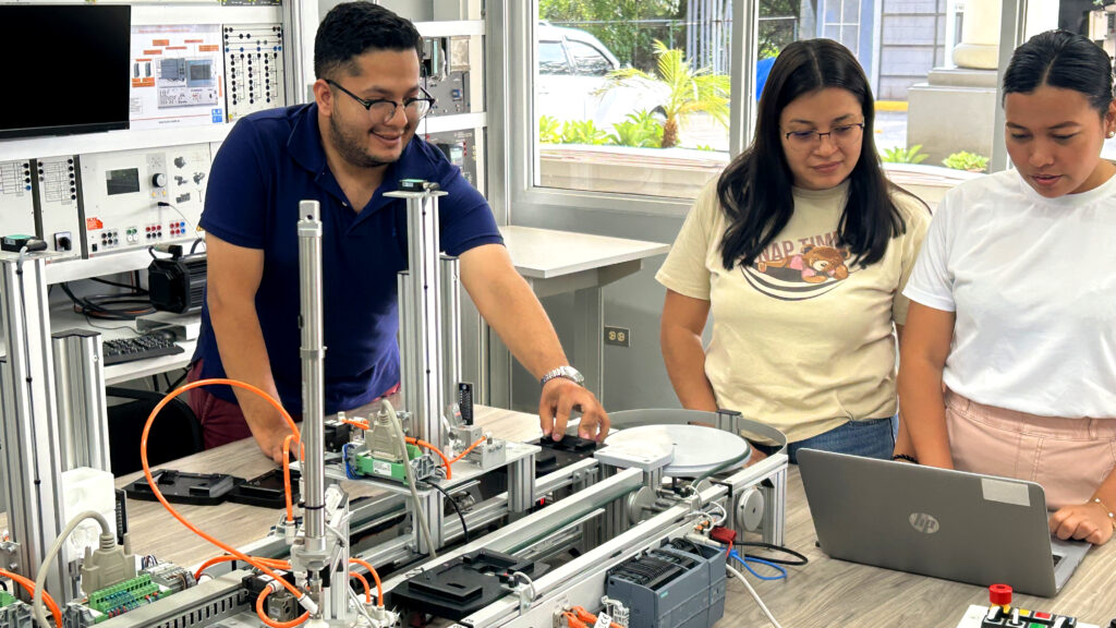 3 Personen arbeiten an einer Industrie-4.0-Anlage von Lucas-Nülle