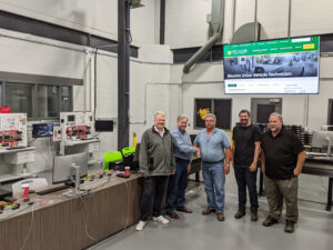 5 Personen am St. Clair College in Kanada stehen neben Kfz-Trainingssystemen von Lucas-Nülle.