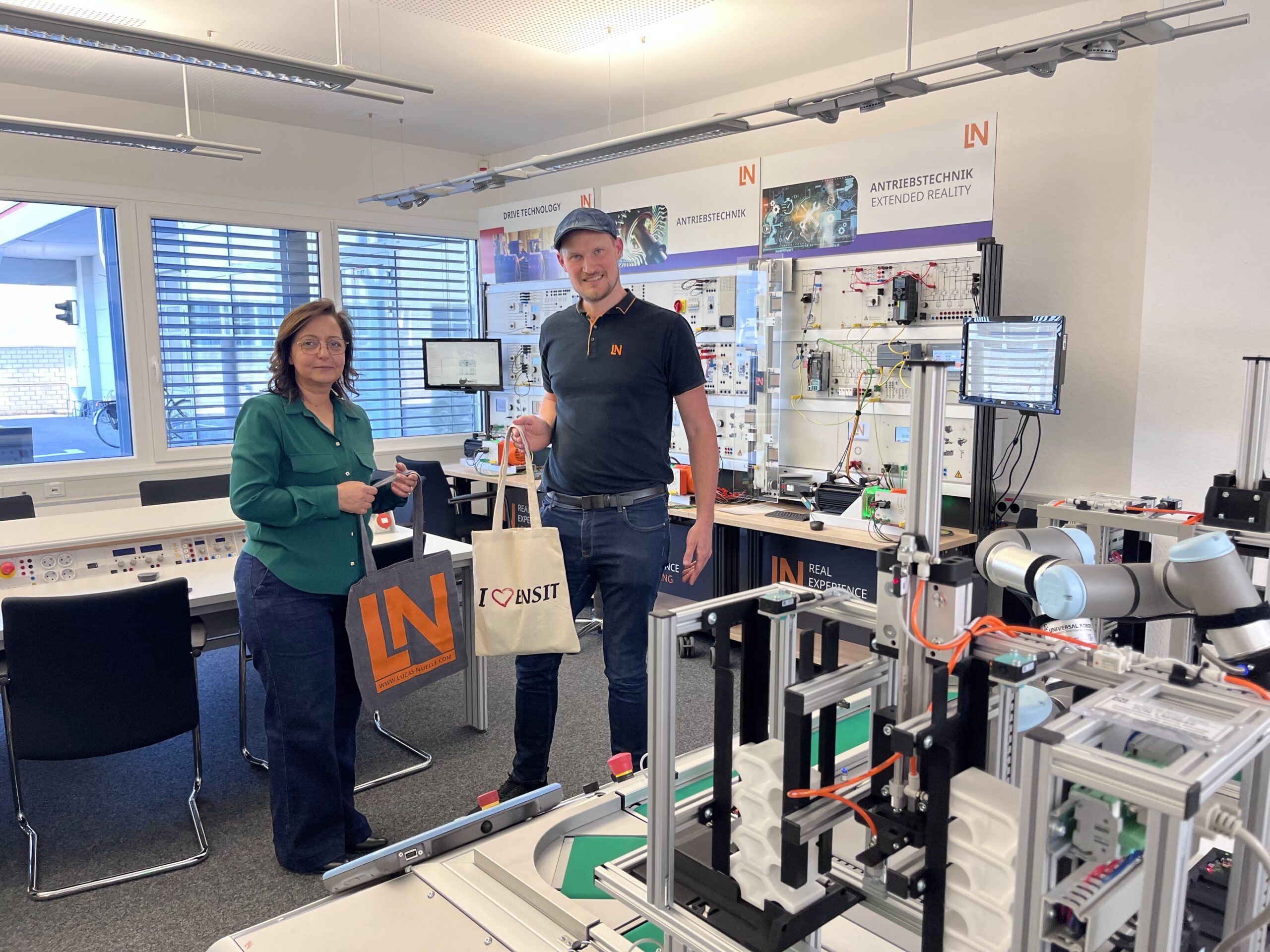 Zwei Personen stehen vor einer Industrie-4.0-Trainingsanlage von Lucas-Nülle